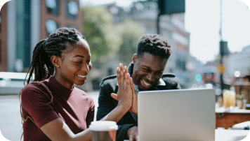 Two employees celebrating with a highfive gesture. achive