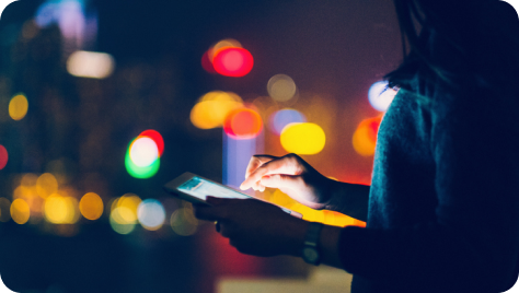 A person holding a tablet in her hands and operating that tablet.